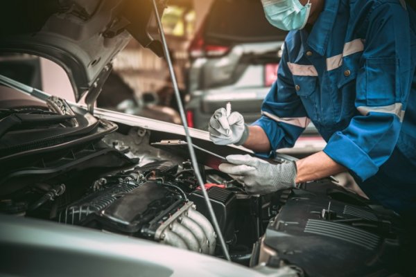 Car mechanic looking at a car engine